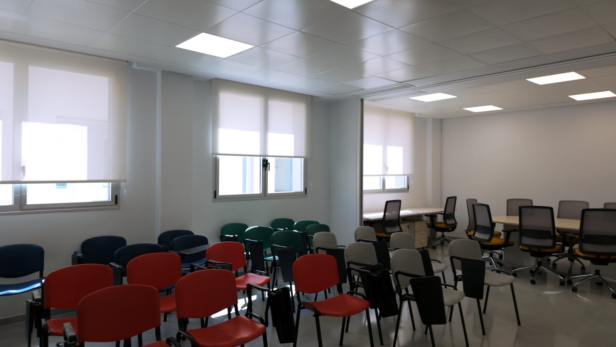Sala de formación con sillas de pala y mesas, donde se proyectan y comentan las grabaciones.